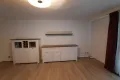 two white cupboards and one shelf on the wall of the living room