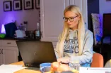 Eine Studentin Zuhause vor dem Laptop 