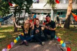 Studierende sitzend auf Weg im Garten mit Fliegern
