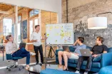 Gruppe von Menschen vor einem Flipchart beim Brainstorming