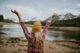 Mädchen mit Armen hoch vor Bergkulisse