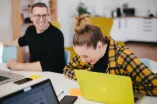 Zwei Personen lachend mit Laptop