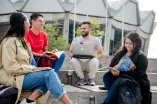 Studierendengruppe sitzend vor dem Audimax