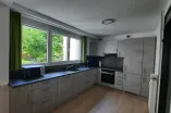 grey kitchen equipped with plenty of kitchen appliances and storing room
