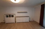 two white cupboards and one shelf on the wall of the living room