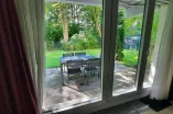 terrace with table and  chairs surrounded by lawn