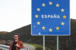 Dominik stands in front of the border sign of Spain