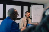 Two Workshop participants at the Academic Freedom Forum, Whiteboard in the Background.