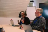 Two workshop participents disscussing in front of their Laptops