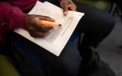 Person markiert etwas auf einem Blatt