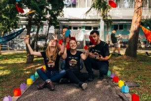 Studierende sitzend auf Weg im Garten mit Fliegern