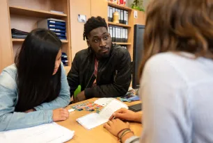 Zwei Personen werden von einer Mitarbeiterin des International Office beraten