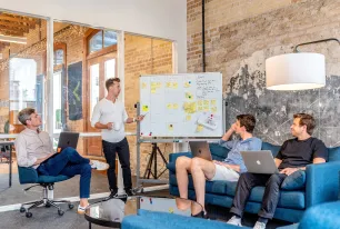 Gruppe von Menschen vor einem Flipchart beim Brainstorming