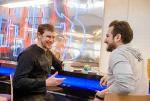 Zwei Jungs trinken Kaffee und reden dabei mit einander