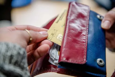 Krankenkassenkarte wird aus einem Portemonaie gezogen