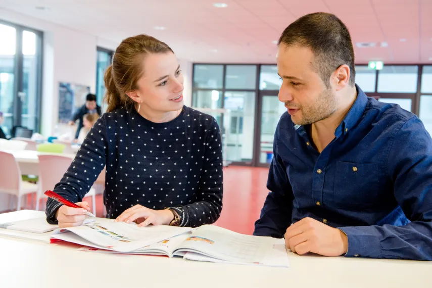 Zwei unterhaltende Personen mit Deutschbüchern