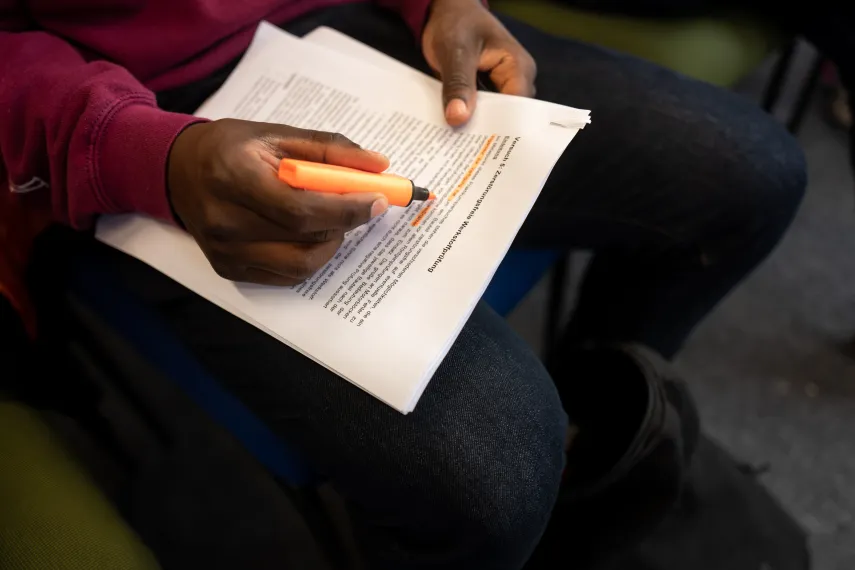 Person markiert etwas auf einem Blatt