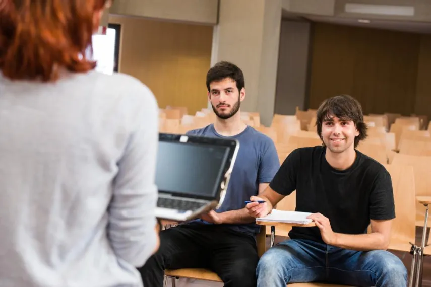 zwei geflüchtete Studierende werden unterrichtet im Horsaal