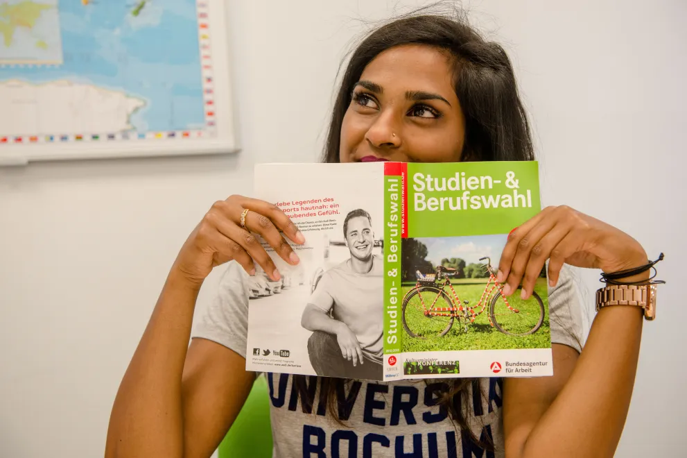 Studieninteressierte mit Buch zur Studien- und Berufswahl