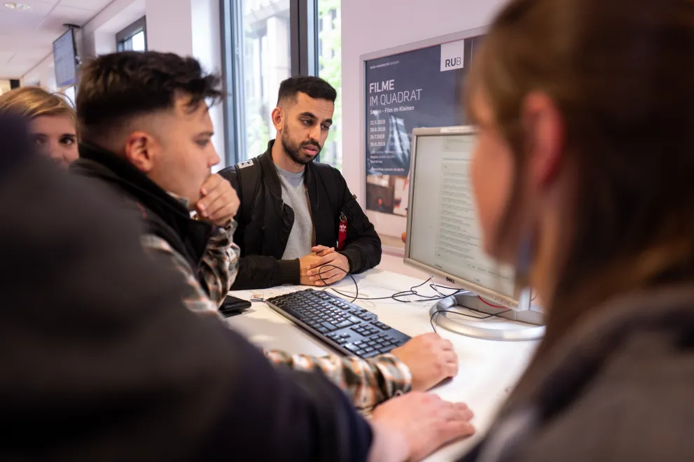 Eine Gruppe von Personen um einen PC 