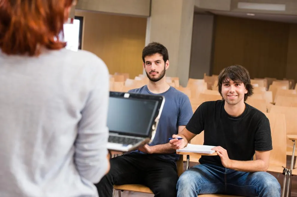 zwei geflüchtete Studierende werden unterrichtet im Horsaal