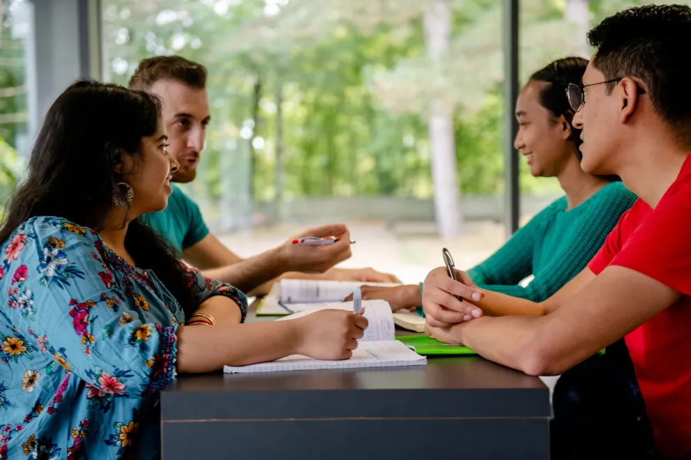 Gruppe Studierender sitzt am Tisch und unterhält sich