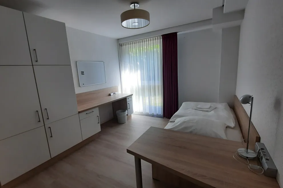 bedroom with bed, two desks, spacious wardrobe