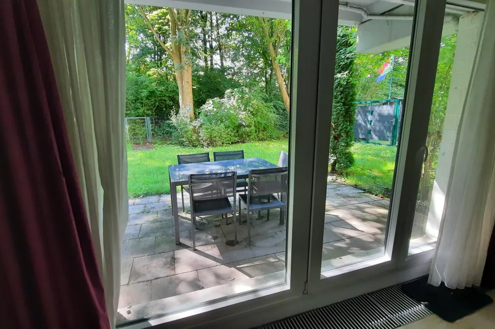 terrace with table and  chairs surrounded by lawn