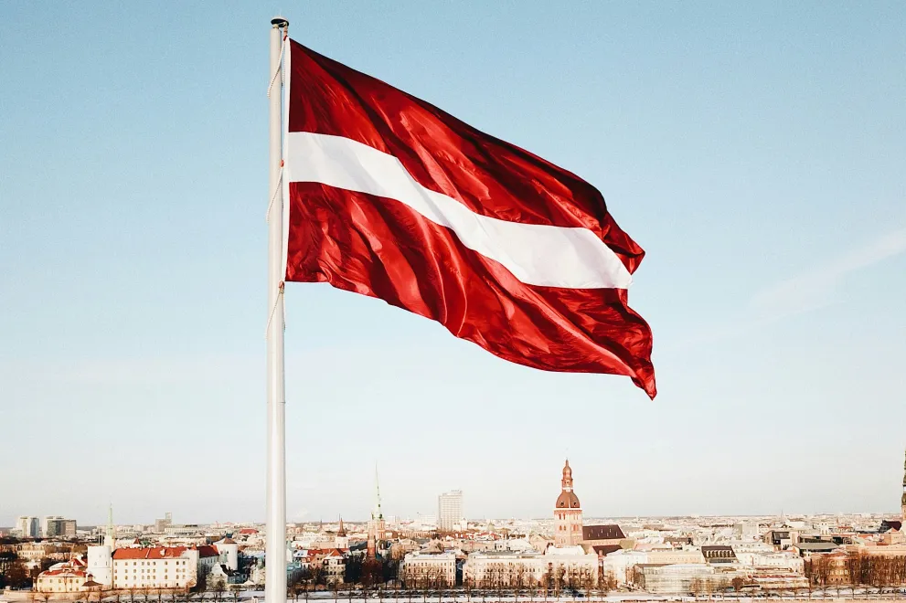 Flagge Lettlands und Riga im Hintergrund
