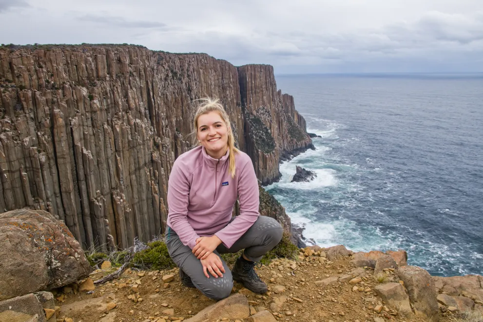 Romy sits on a steep coast in Australia