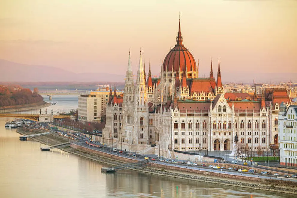 Eine Kirche an einem Fluss, die von der Abendsonne beleuchtet wird.