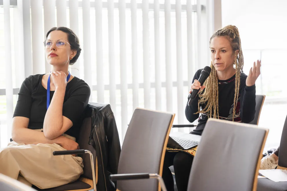 A Woman from the audience speaks into a microphone at the Academic Freedom Forum