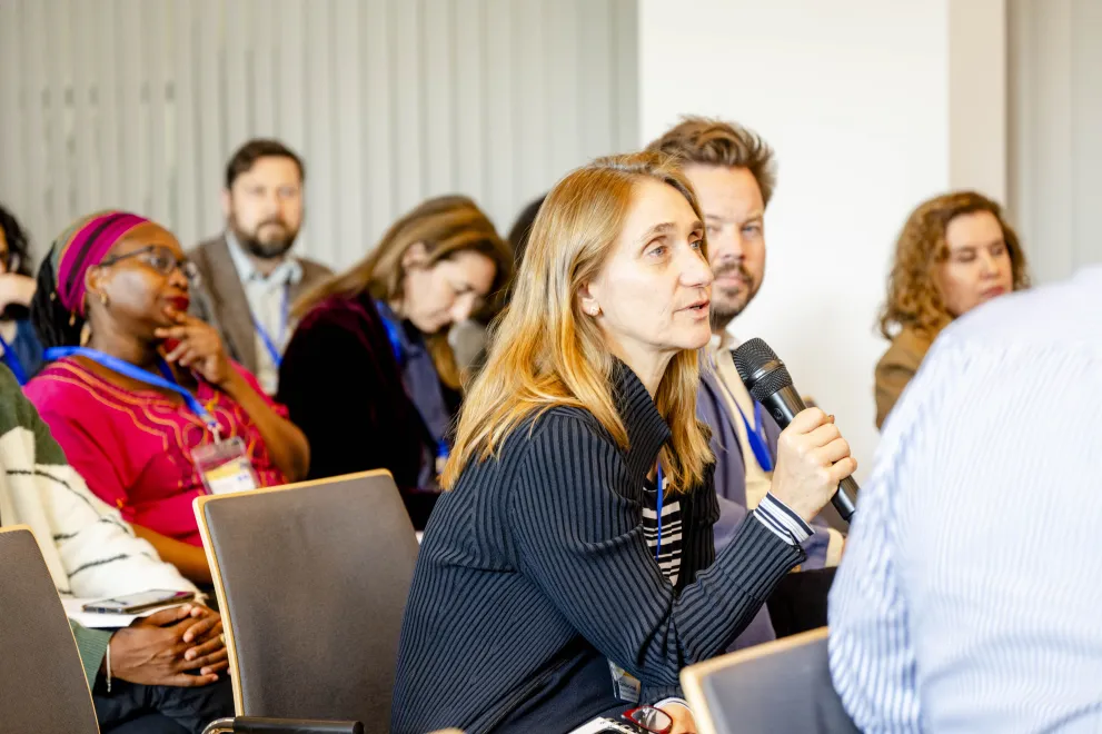 A Woman from the audience speaks into a microphone at the Academic Freedom Forum