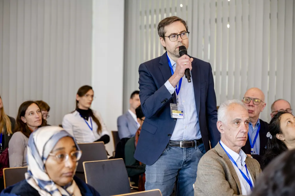 A man from the audience at Academic Freedom Forum speaks into a microphone standing up