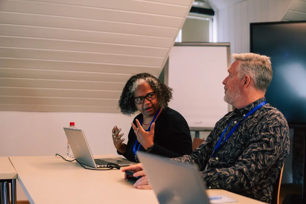 Two workshop participents disscussing in front of their Laptops