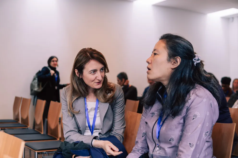 Two women from the audience speak to each other at the Academic Freedom Forum