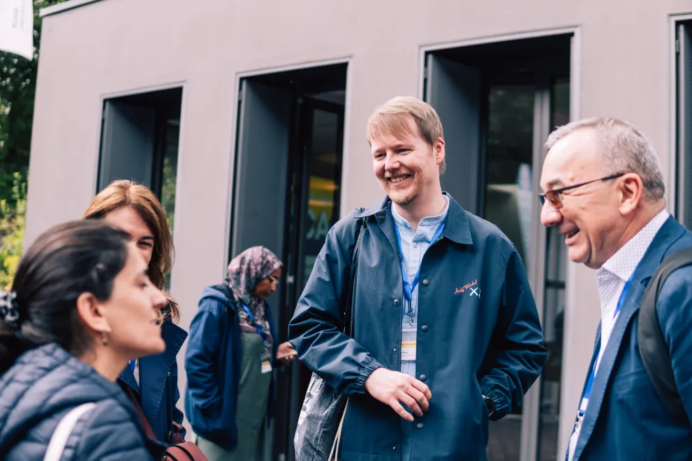 Participants talking th each other in front of a building