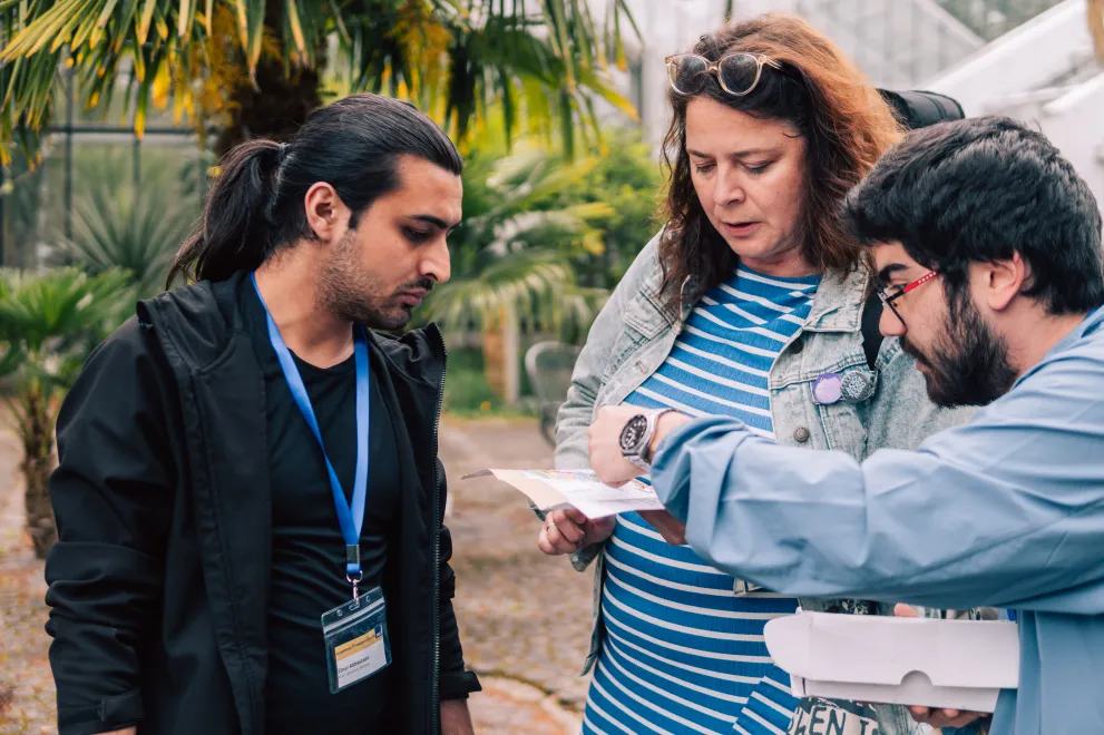 Three Paticipants of the Garden of Sanctuary Walk are looking at a map.