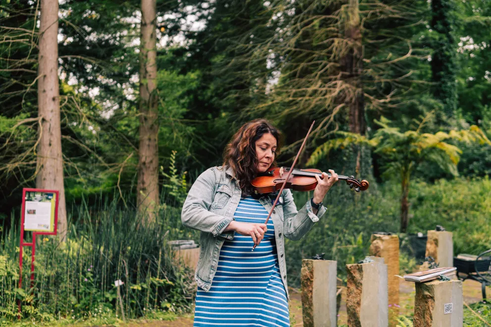 A woman playing the Violin in the Botanical Gardens 